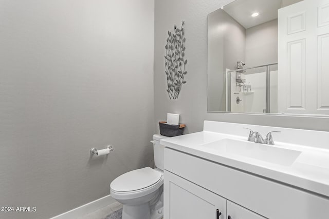 bathroom with toilet, vanity, and walk in shower