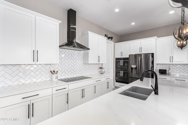 kitchen featuring white cabinets, wall chimney exhaust hood, and black appliances