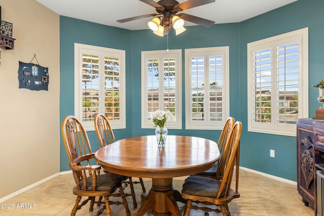 dining area with light tile patterned flooring, baseboards, and ceiling fan