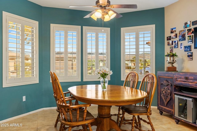 dining space featuring light tile patterned flooring, a ceiling fan, and baseboards