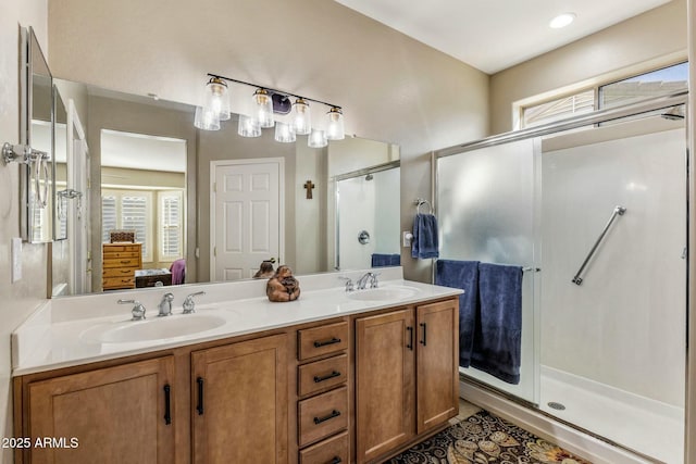 ensuite bathroom with double vanity, a stall shower, ensuite bath, and a sink