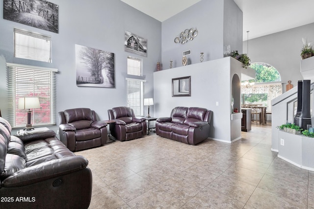 tiled living room featuring a towering ceiling