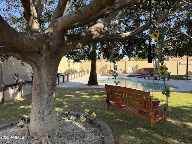 view of community with a patio, a swimming pool, and a lawn