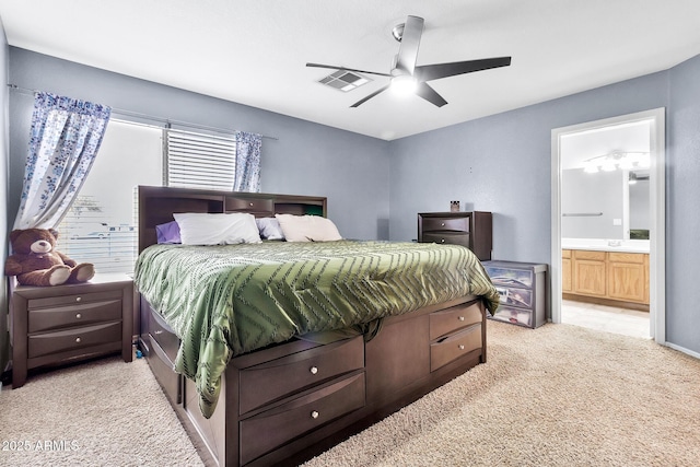 bedroom featuring ceiling fan, ensuite bath, and light carpet