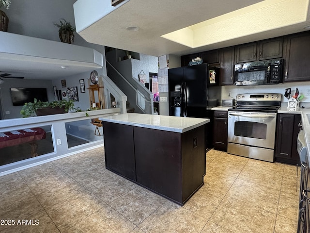 kitchen featuring light tile patterned flooring, a kitchen island, ceiling fan, black appliances, and dark brown cabinets