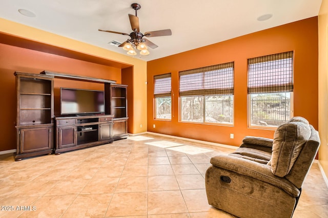 living room featuring light tile patterned flooring, baseboards, visible vents, and ceiling fan