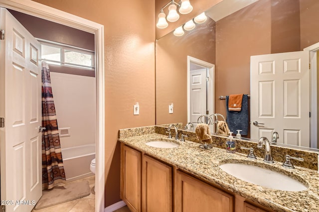 full bathroom featuring tile patterned flooring, double vanity, toilet, and a sink