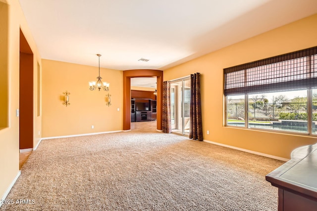 unfurnished room featuring a notable chandelier, light colored carpet, baseboards, and visible vents