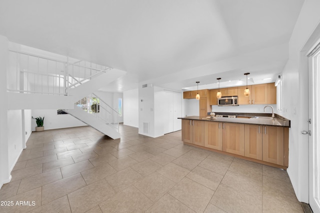 2812 E Clarendon Ave, Phoenix, AZ 85016 - kitchen featuring open floor plan, dark countertops, stainless steel microwave, a peninsula, and light tile patterned flooring