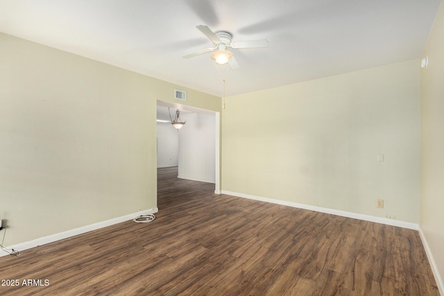 unfurnished room featuring baseboards, visible vents, wood finished floors, and a ceiling fan