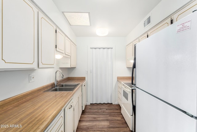 kitchen with light countertops, a sink, dark wood-style floors, white appliances, and visible vents