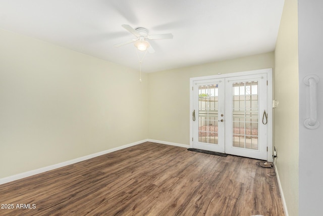 empty room with french doors, a ceiling fan, baseboards, and wood finished floors
