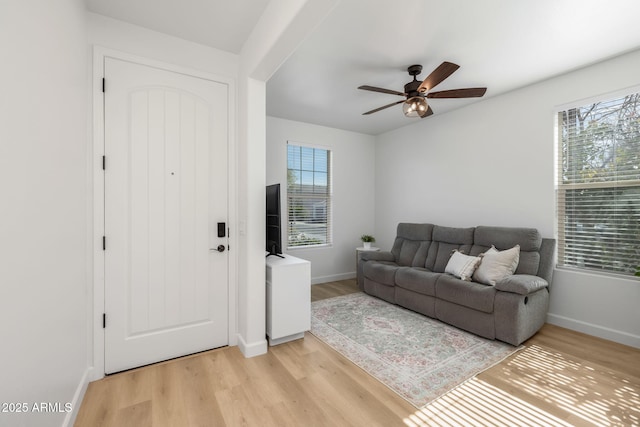 living room with ceiling fan, a healthy amount of sunlight, and light wood-type flooring