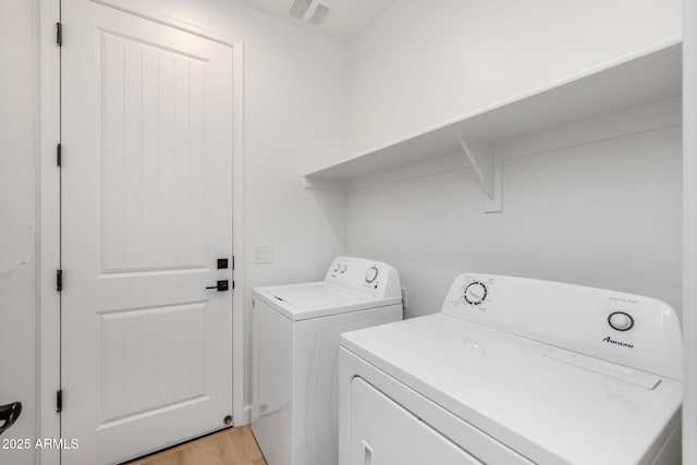 clothes washing area featuring light hardwood / wood-style flooring and independent washer and dryer