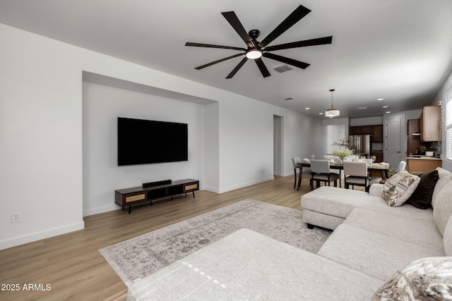 living room featuring light hardwood / wood-style flooring and ceiling fan