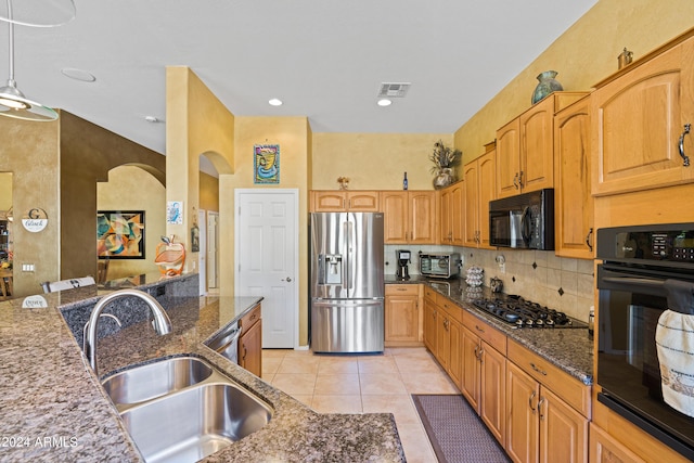 kitchen with black appliances, sink, decorative backsplash, dark stone countertops, and light tile patterned floors