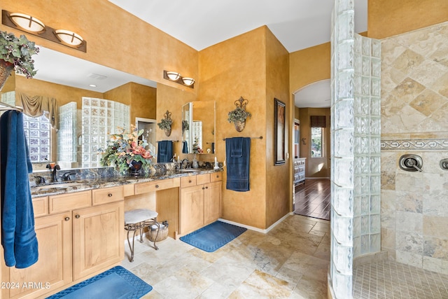 bathroom with vanity and tiled shower