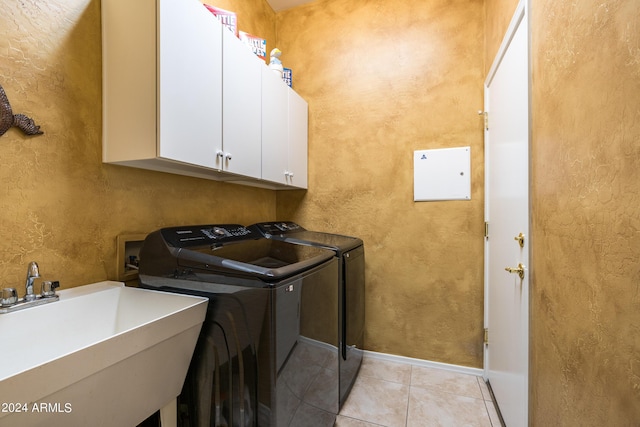 washroom with sink, light tile patterned floors, cabinets, and independent washer and dryer