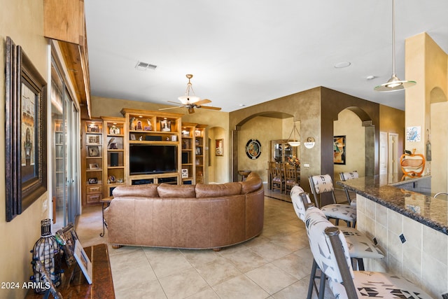 tiled living room with ceiling fan