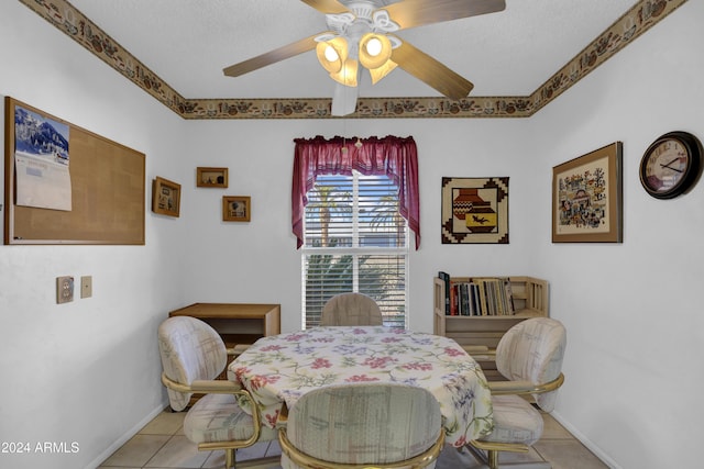 dining space featuring ceiling fan, light tile patterned floors, and a textured ceiling