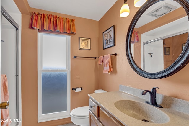 bathroom featuring toilet, vanity, and walk in shower