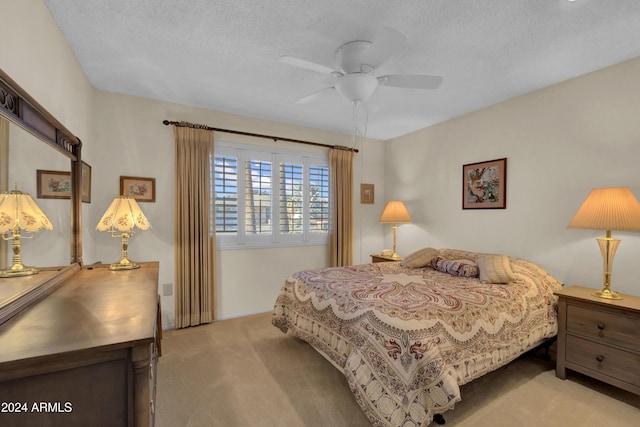 carpeted bedroom featuring ceiling fan and a textured ceiling