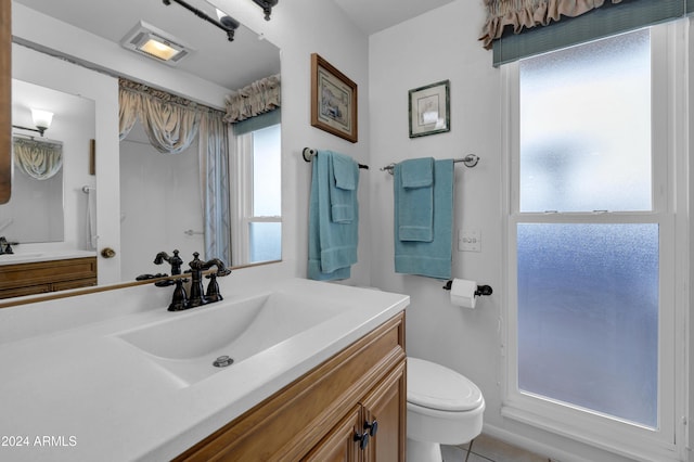 bathroom featuring tile patterned floors, vanity, and toilet