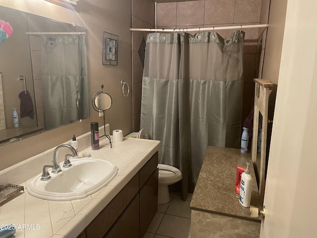 bathroom with tile patterned flooring, vanity, a textured wall, toilet, and a shower with curtain
