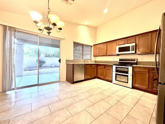 22951 W Loma Linda Blvd, Buckeye, AZ 85326 - kitchen featuring stainless steel appliances, a chandelier, brown cabinets, hanging light fixtures, and recessed lighting
