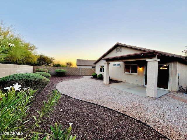 22951 W Loma Linda Blvd, Buckeye, AZ 85326 - back of house at dusk featuring a patio area, a fenced backyard, and stucco siding