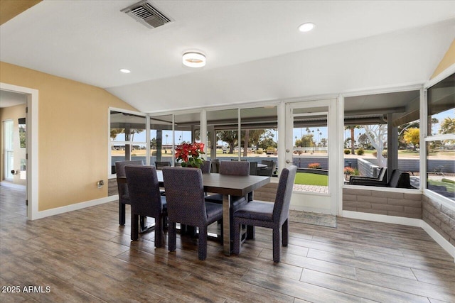 dining space featuring plenty of natural light, dark hardwood / wood-style floors, and vaulted ceiling