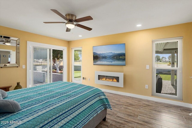 bedroom with hardwood / wood-style flooring, access to outside, and ceiling fan