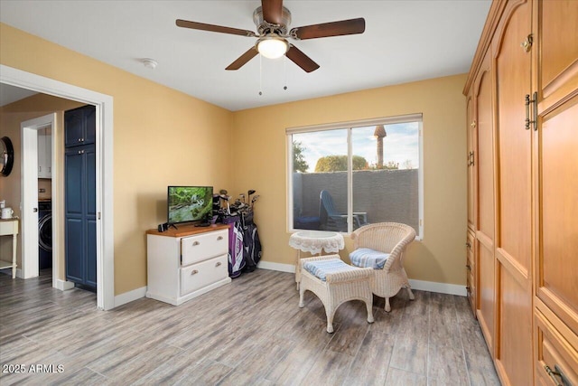 living area featuring light hardwood / wood-style flooring and ceiling fan