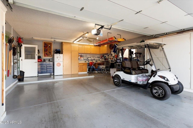 garage featuring a garage door opener, white fridge, and a workshop area