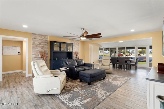 living room featuring ceiling fan and light hardwood / wood-style floors