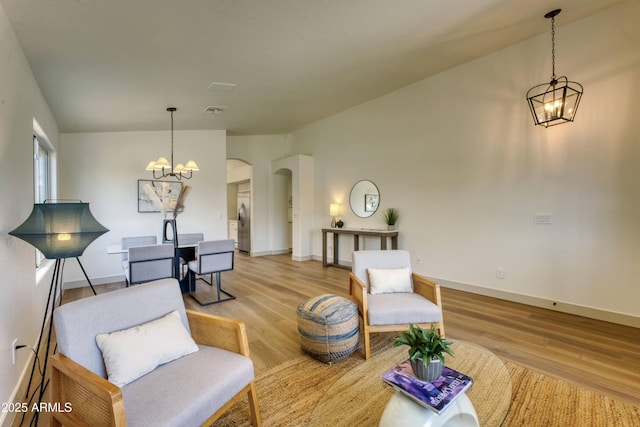 3940 E Heather Ct, Gilbert, AZ 85234 - living room with a chandelier, light wood-style floors, and arched walkways
