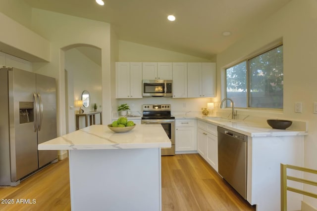 3940 E Heather Ct, Gilbert, AZ 85234 - kitchen featuring appliances with stainless steel finishes, lofted ceiling, white cabinets, a kitchen island, and light wood-style flooring