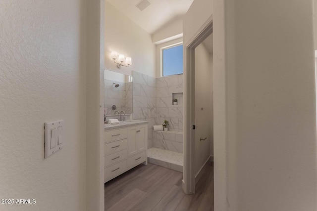 3940 E Heather Ct, Gilbert, AZ 85234 - bathroom featuring wood finished floors, walk in shower, vanity, vaulted ceiling, and a textured wall