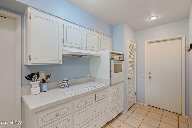 kitchen featuring white cabinetry, white appliances, and light tile patterned floors