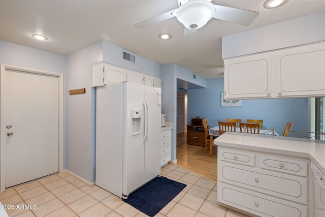 kitchen with white cabinetry, white refrigerator with ice dispenser, light tile patterned floors, and ceiling fan