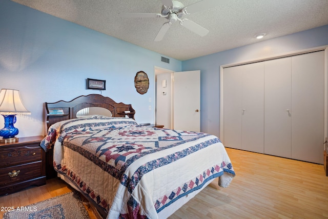 bedroom with ceiling fan, a closet, a textured ceiling, and light wood-type flooring