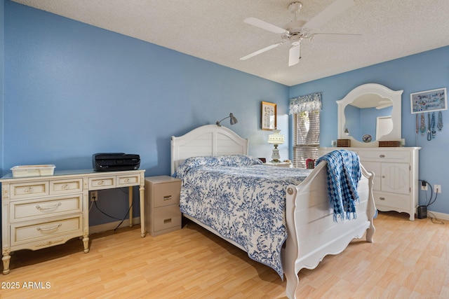 bedroom with ceiling fan, a textured ceiling, and light hardwood / wood-style flooring