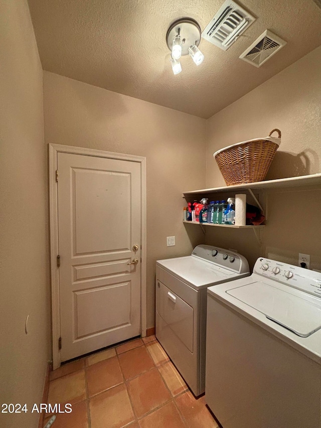 laundry area with independent washer and dryer, a textured ceiling, and light tile patterned floors