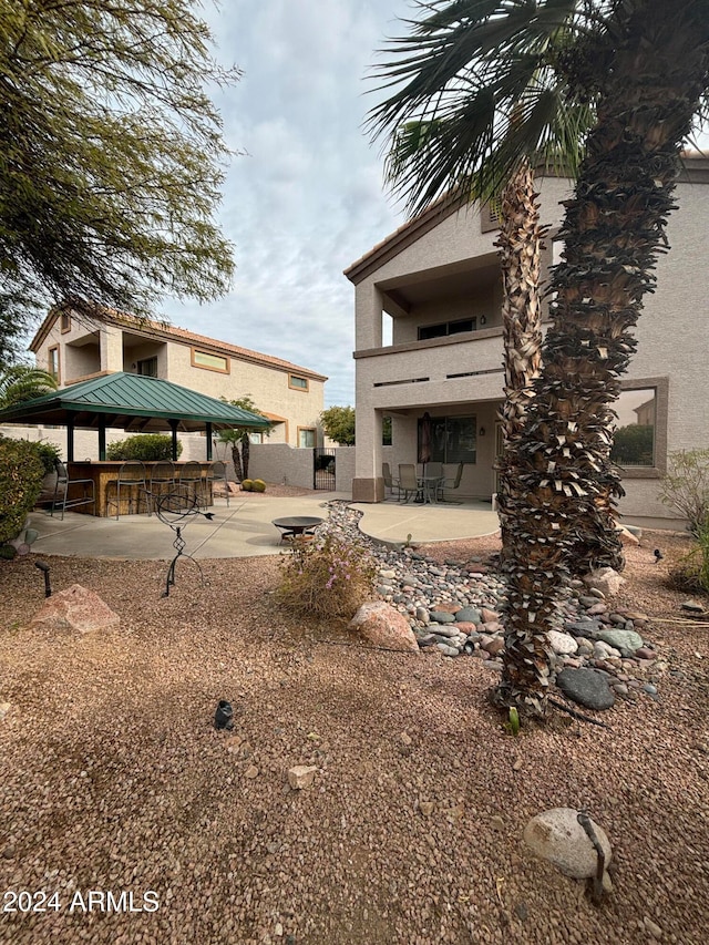 rear view of house featuring a gazebo and a patio