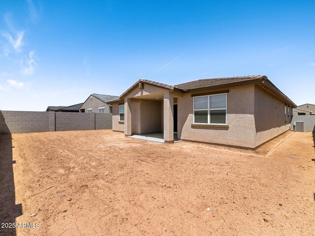 back of house featuring a patio, a tile roof, a fenced backyard, and stucco siding