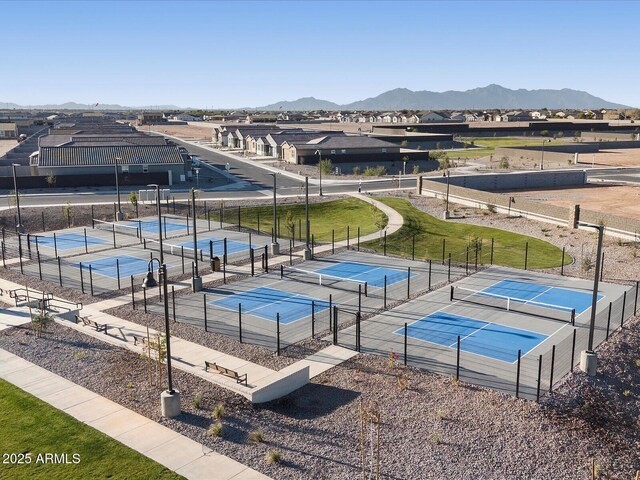 view of swimming pool featuring a tennis court, fence, and a mountain view
