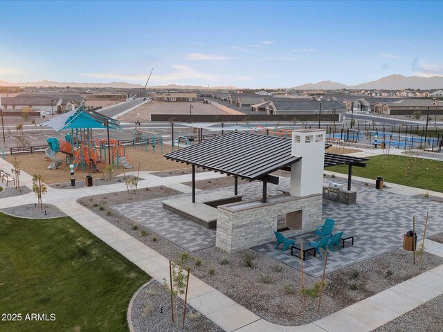 view of home's community with fence, a mountain view, and playground community