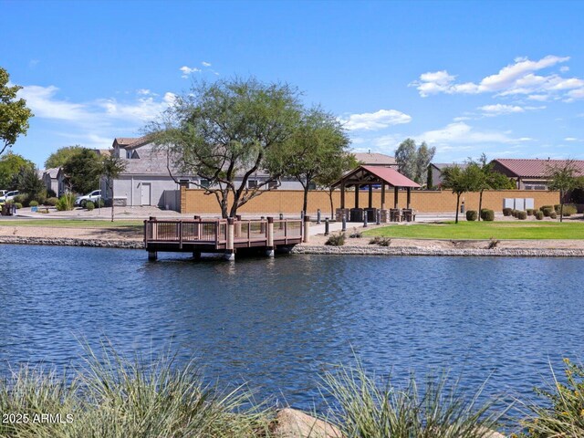 view of dock featuring a water view, a gazebo, and a residential view