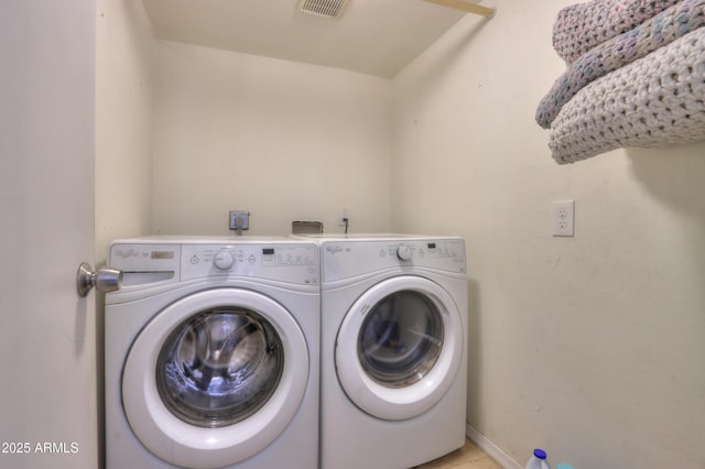 clothes washing area with baseboards, visible vents, independent washer and dryer, and laundry area