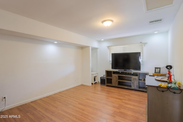 living room featuring baseboards, visible vents, and light wood-style flooring